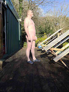 Naturist nudist nude naked penis man standing outdoors in natural light.
