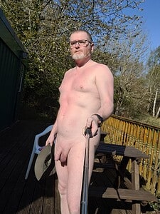 Naturist nudist nude naked penis man taking selfie outside in natural setting.