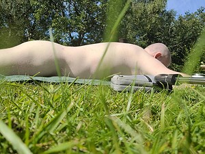 Naturist nudist nude naked penis relaxing outdoors on grass.