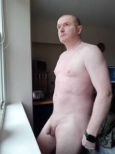 Naturist nudist nude naked penis of a man standing by a window.